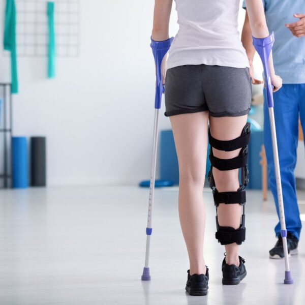 woman walking with leg brace and crutches