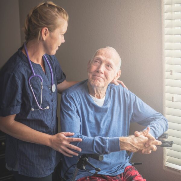 caretaker woman smiling at elderly man
