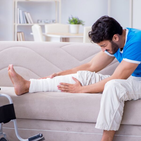 man on couch with hurt leg