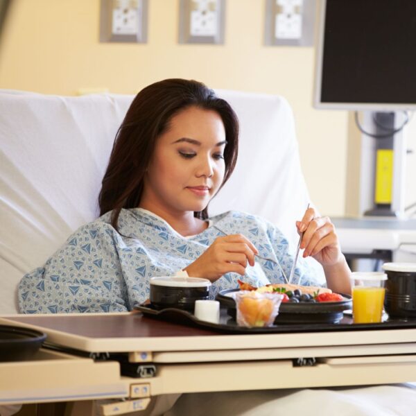 woman eating from a hospital bed