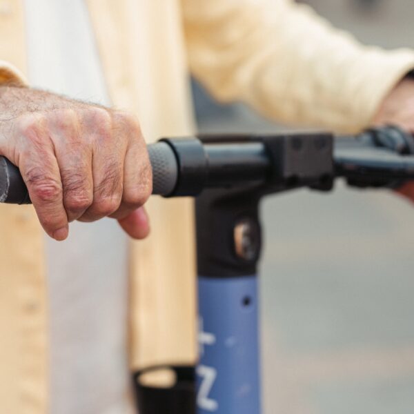 Elderly hands on scooter brakes