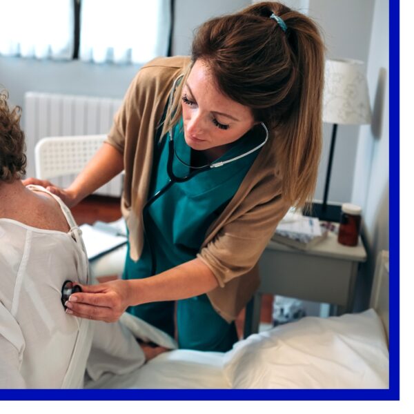 Woman caring for an elderly woman in hospital bed