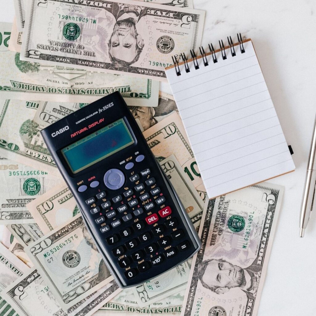 A calculator with money in the background
